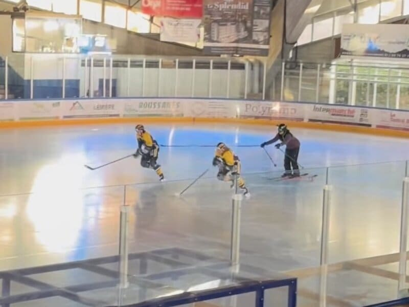 Skier backflips on hockey rink