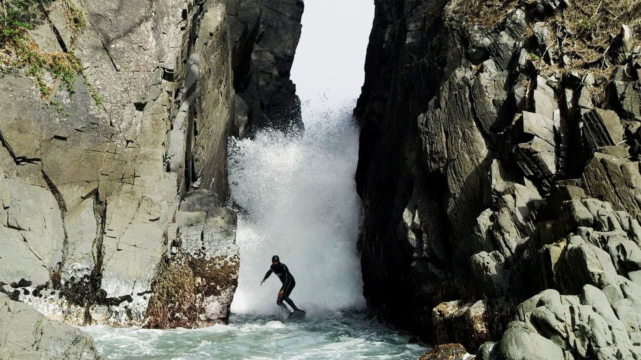 Surfer Rides Between Impossibly Narrow Rock Walls in Japan