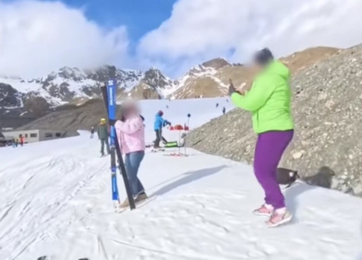 Ski racer busts tourists posing with his skis.