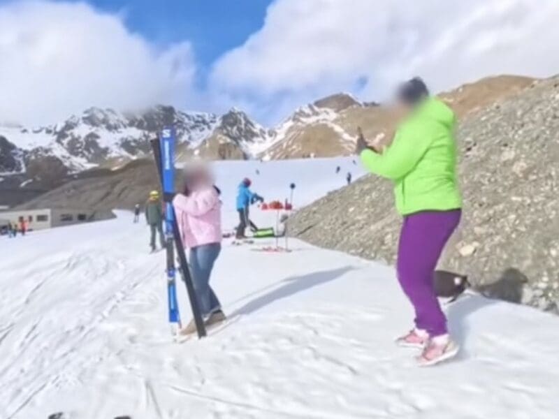 Ski racer busts tourists posing with his skis.