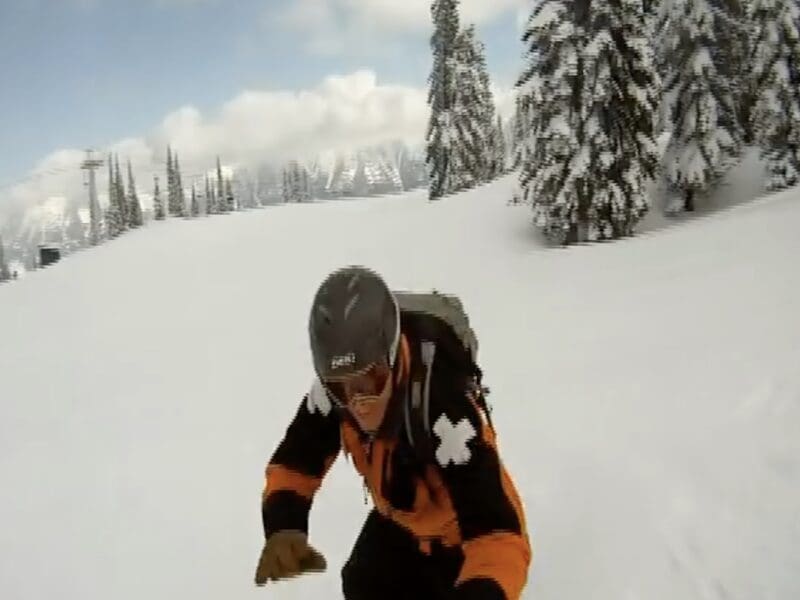 Ski patroller attempts to tackle a snowboarder.