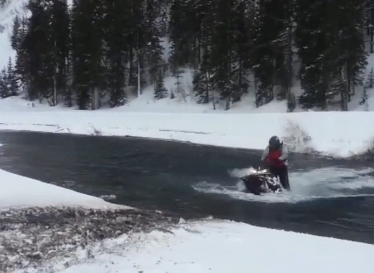 Snowmobile sinks into the river.