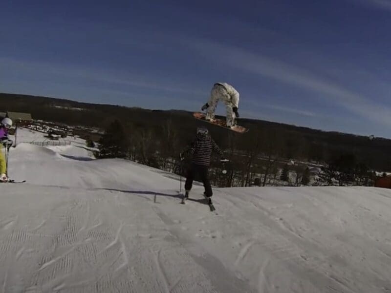Skier standing in landing zone nearly hit.