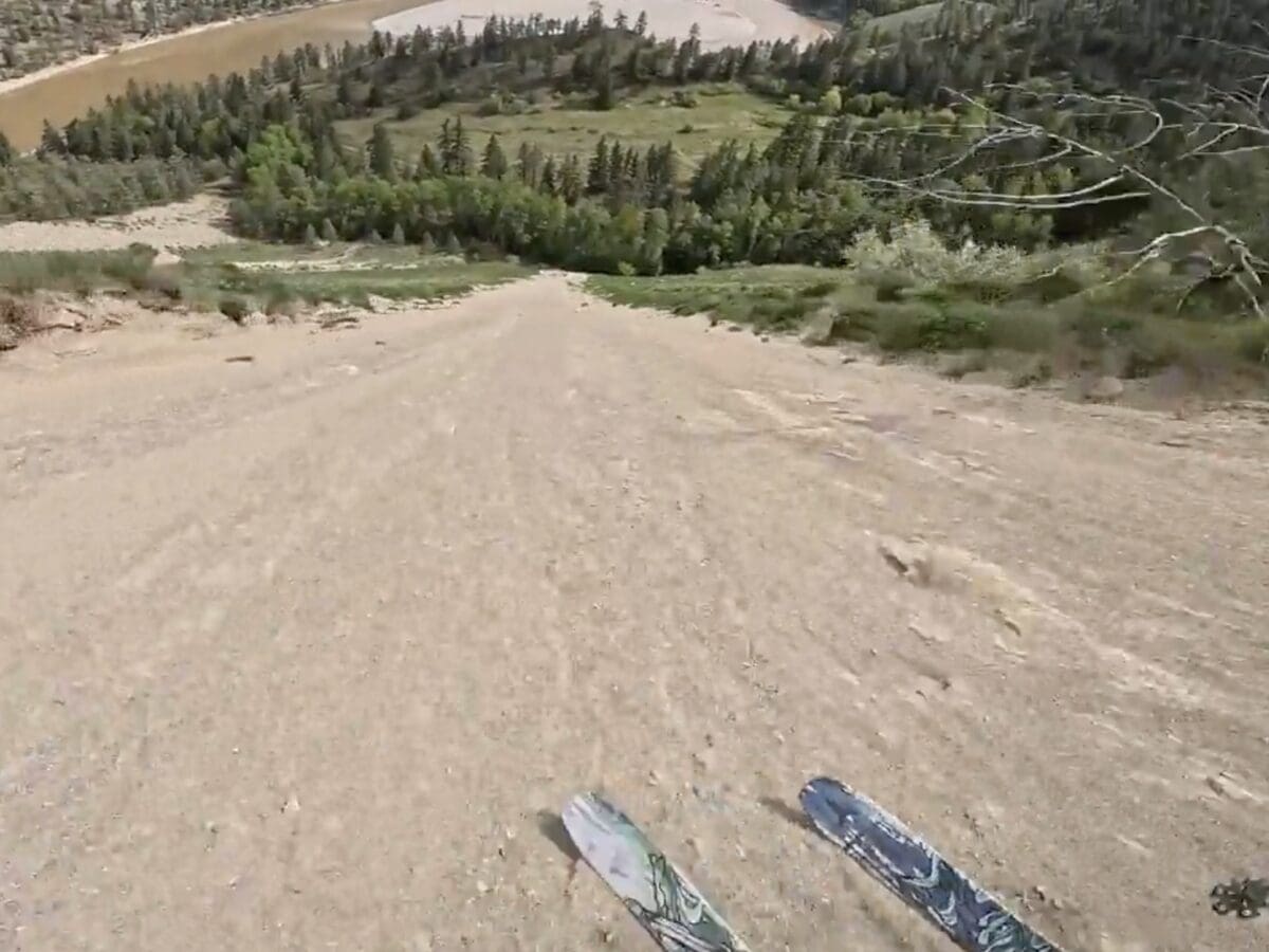 Skier rides a chute of sand.