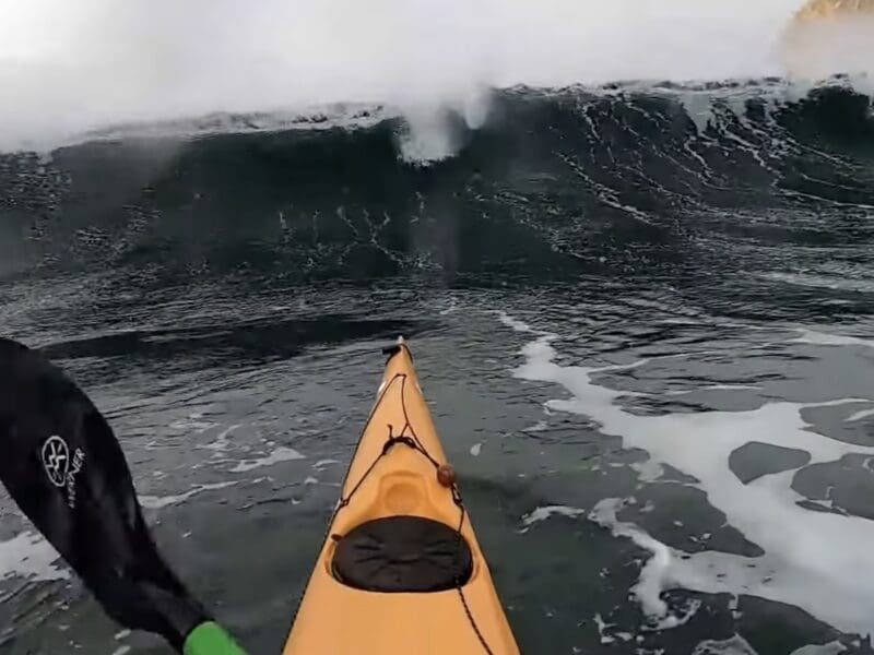 Kayaker rolls through ocean waves.