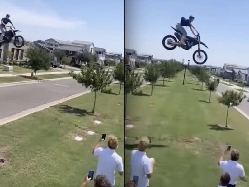 High school stuntman airs dirt bike over suburban street.