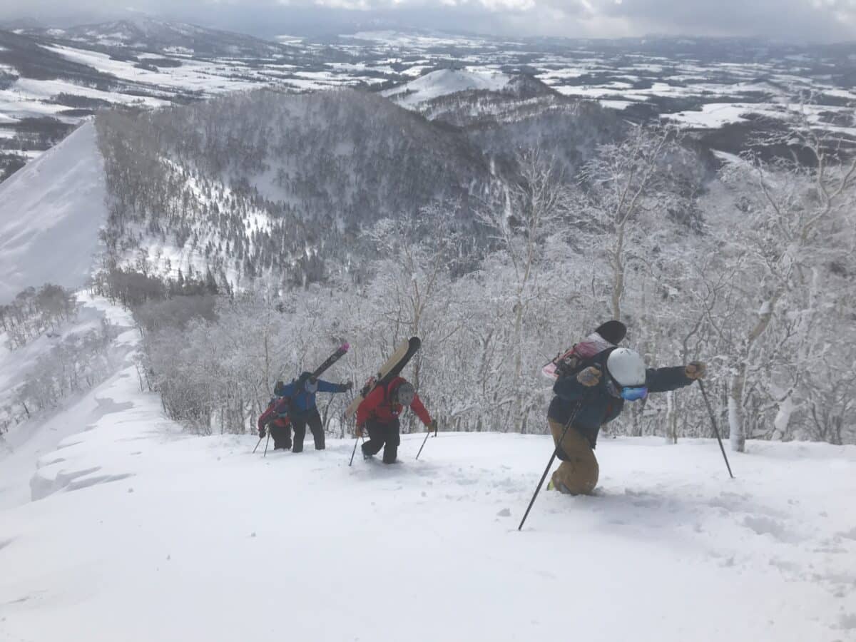 Skiers hiking up a mountainside