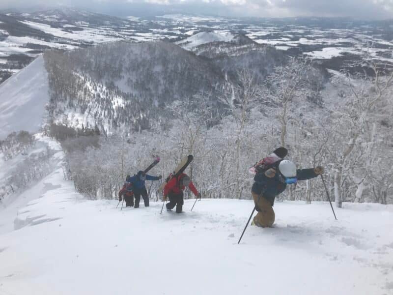Skiers hiking up a mountainside
