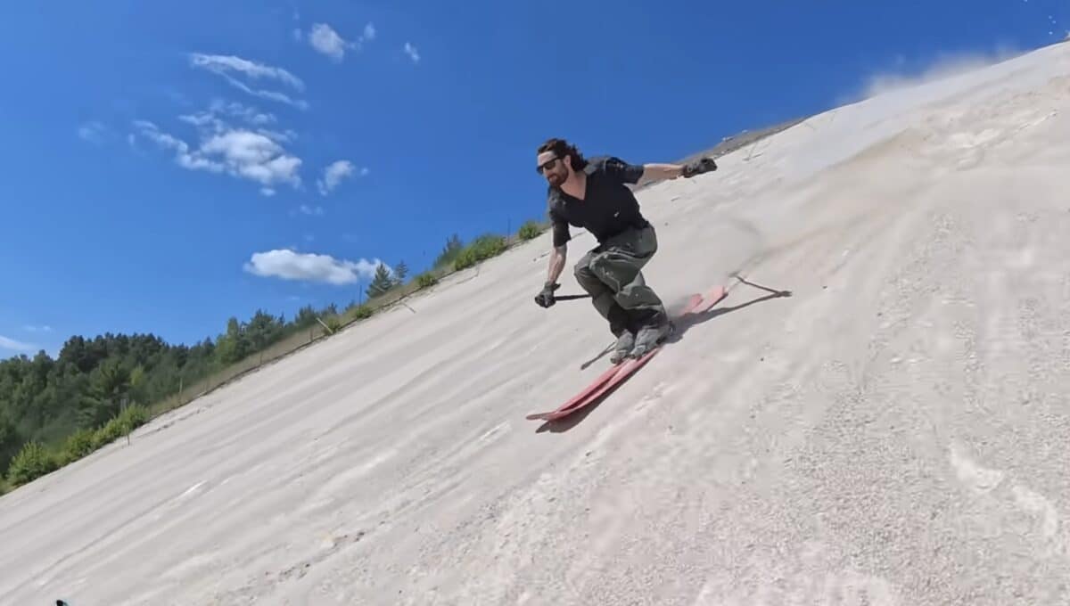Alex Hackel skis on sand.