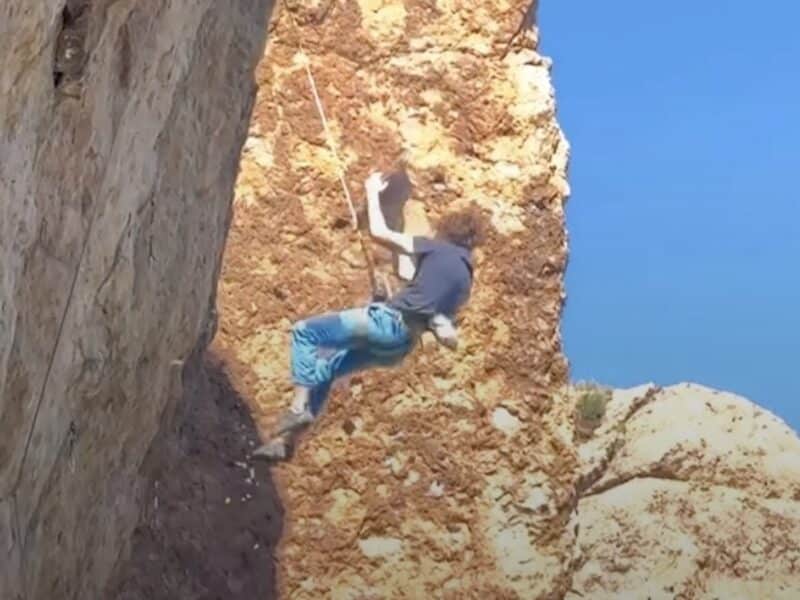 Climber holds onto rock after it breaks away from wall