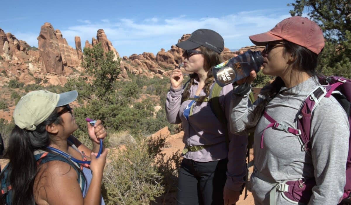 Hikers hydrate in Arches National Park.