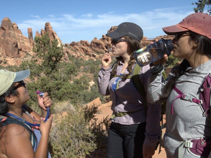 Hikers hydrate in Arches National Park.