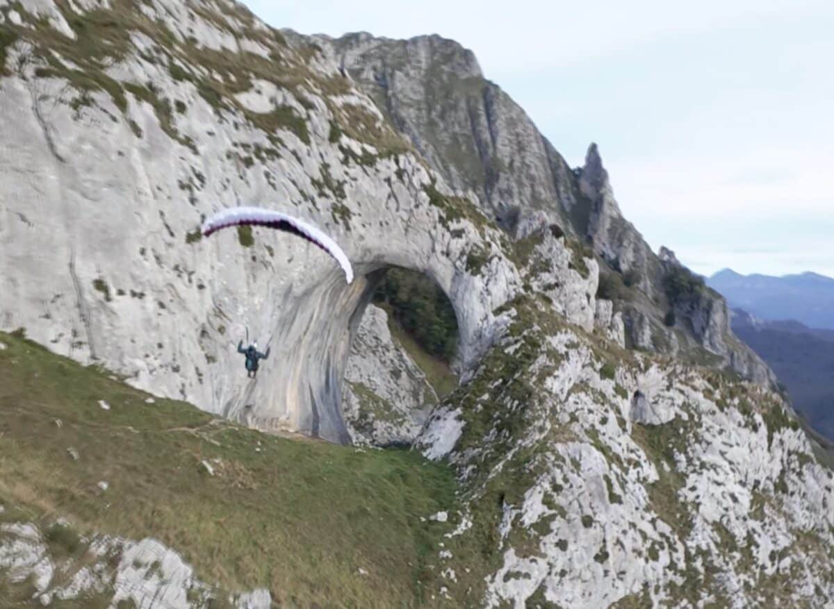 Paraglider flys through Ojo de Buey