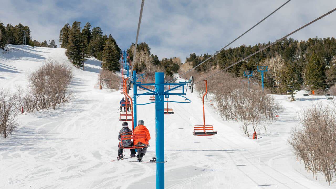 Ski lift at Sandia Peak with snow-covered slopes and trees.