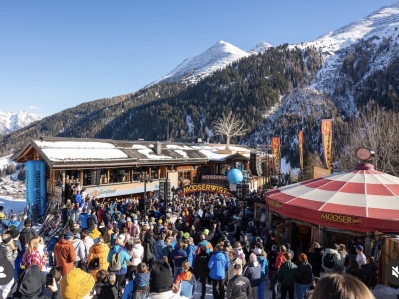 Crowd of skiers and snowboarders at mountain lodge after a day on the slopes.