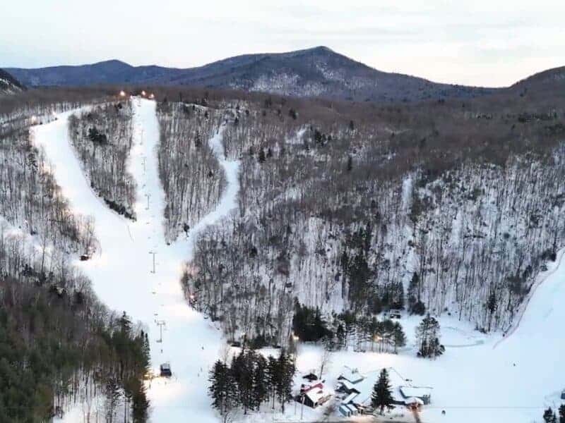 Snow-covered ski slopes and mountain landscape in Vermont during offseason.