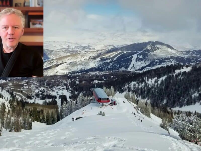 Scenic winter mountain view with ski lift and snow-covered trees.