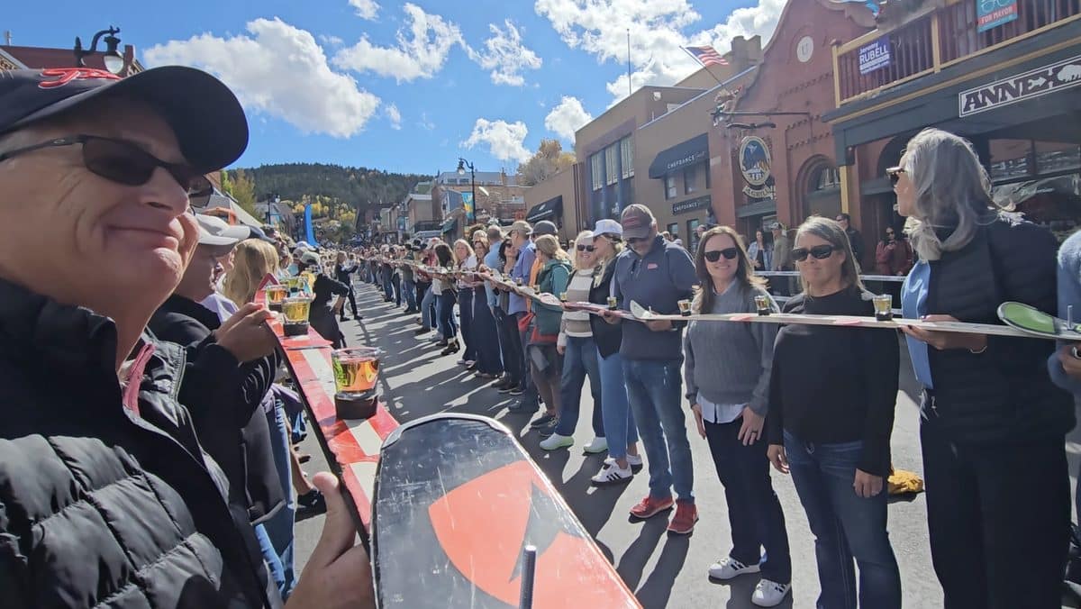 People participating in a community event on a sunny day in a mountain town.