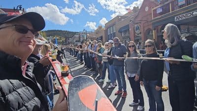 People participating in a community event on a sunny day in a mountain town.