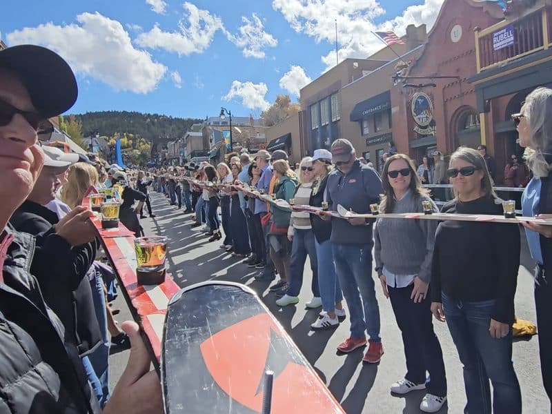 People participating in a community event on a sunny day in a mountain town.
