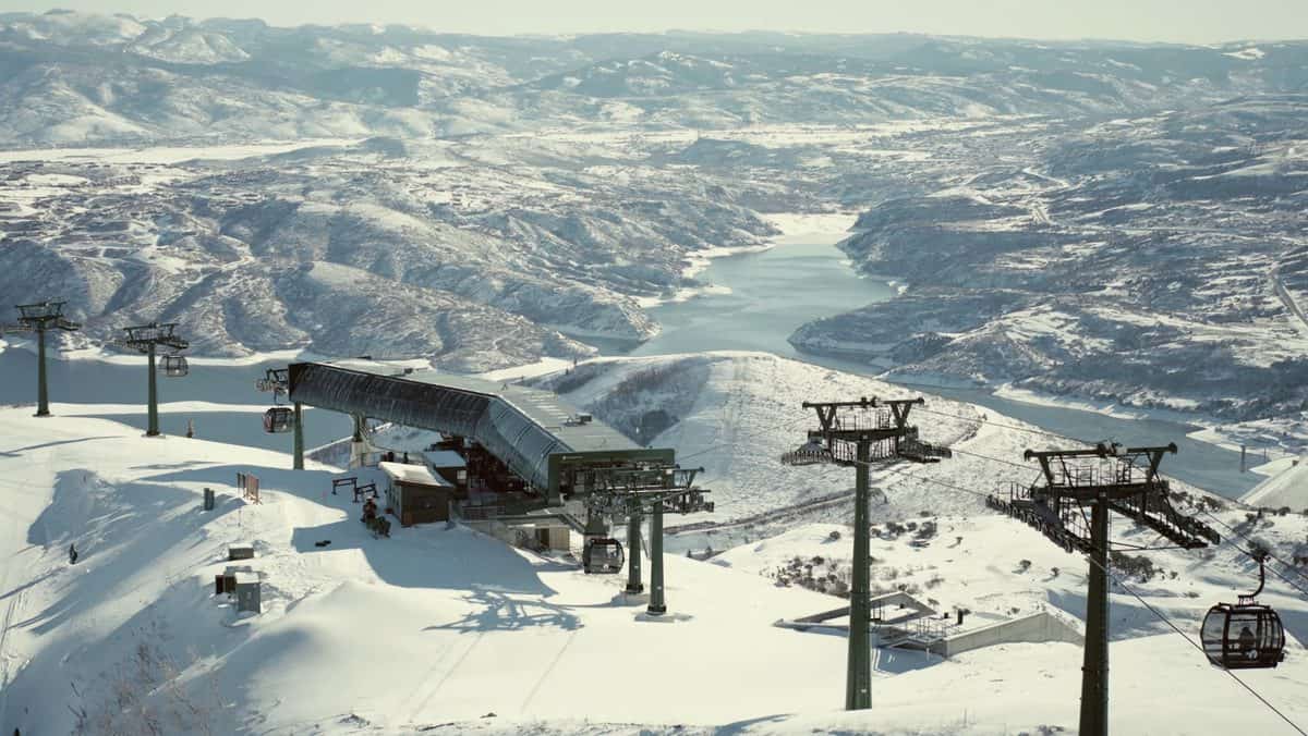 Ski lift and snow-covered slopes at a mountain ski resort.
