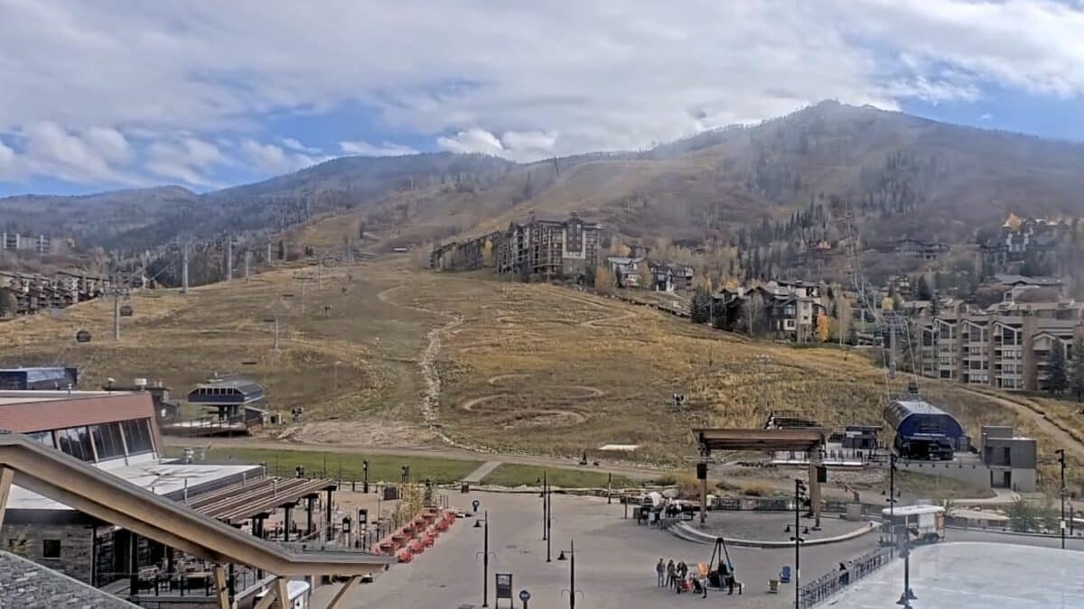 Panoramic view of a mountain town with ski resort buildings and slopes.