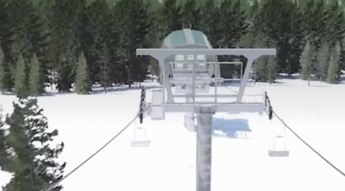 Snow-covered chairlift in a forested mountain area.