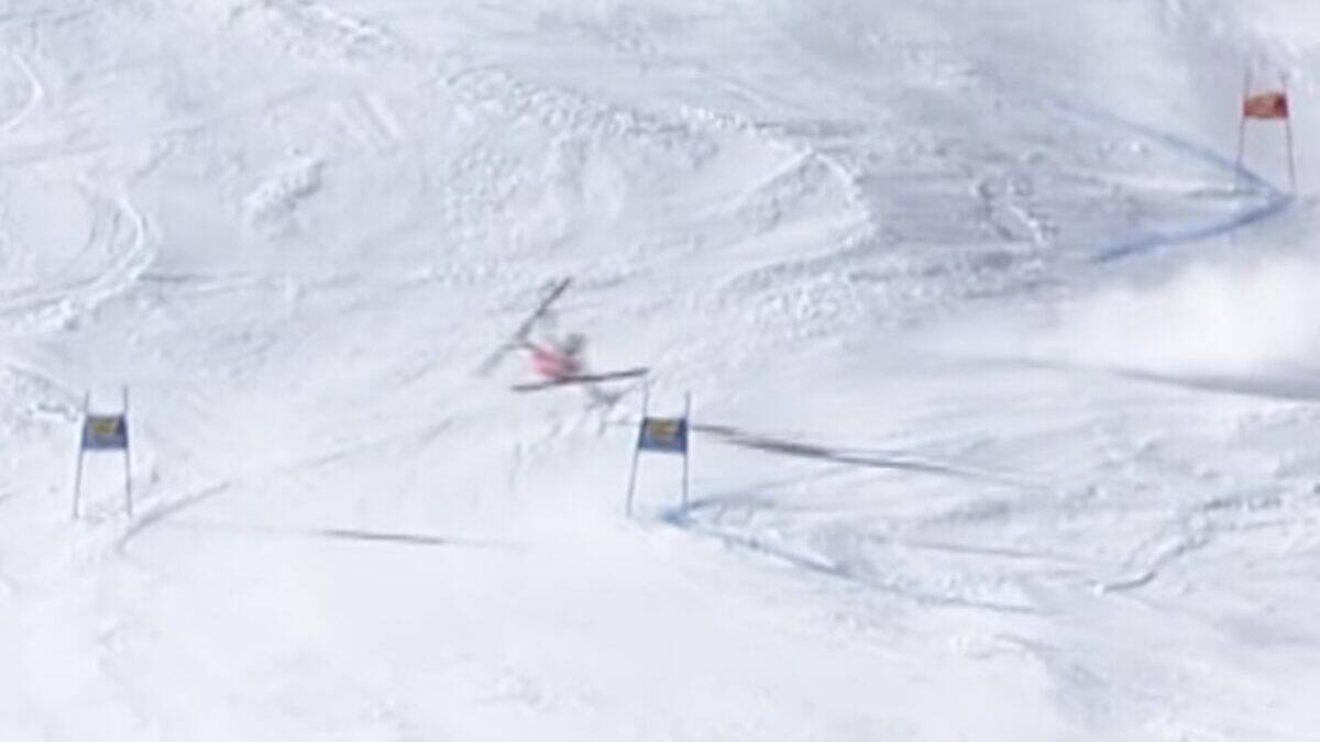Skier navigating a row of gates on a snowy slope with powder and blue shadows.