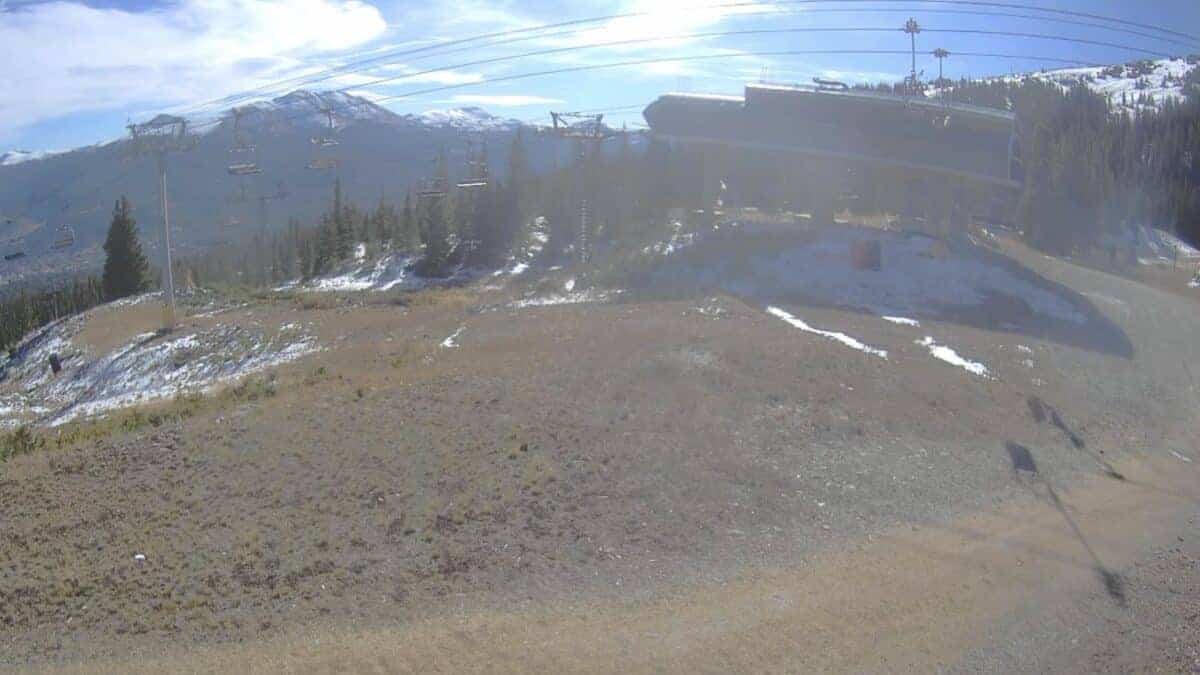 Mountain ski resort chairlift under clear blue sky.