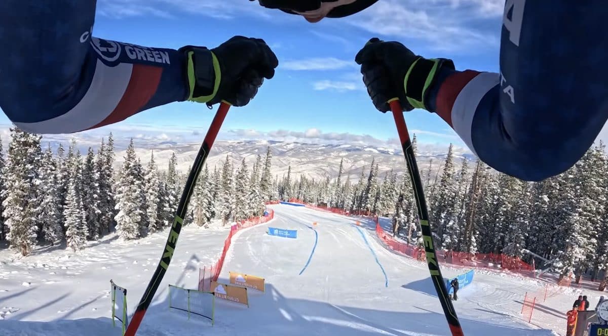 Snowy downhill ski course viewed from cyclist's perspective.